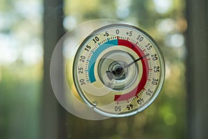 A thermometer of temperature outside the window that hangs on the window