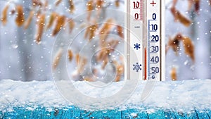 The thermometer on a winter background shows minus 25 degrees