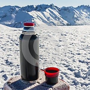 Thermos and a cup of tea bloated stands on the mark border.