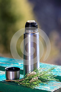 Thermos with tea on a bench