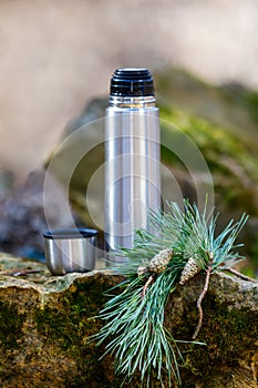 Thermos with tea on a stone