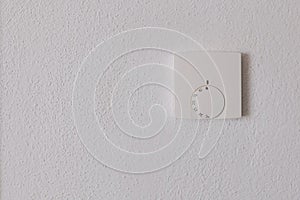 Thermostat with the external and target temperatures indicated. Rotary dial to control and adjust. White wall and white