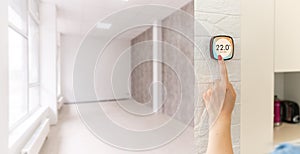 Thermostat smart home domotic control panel on wall for winter house temperature banner panoramic. Energy saving hand