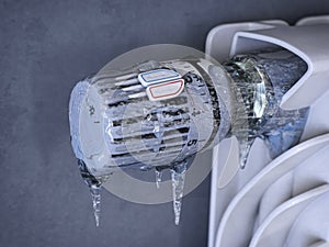 Thermostatic radiator valve with icicles. Energy crisis, sturning off heating for non-payment and saving concept