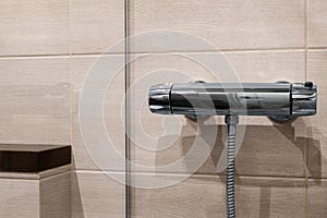 Thermostatic shower faucet on beige  the wall in bathroom