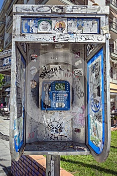 Thessaloniki, Greece, April 27, 2023: Public phone box full of stickers and paint scrawling in the city centre of Thessaloniki on