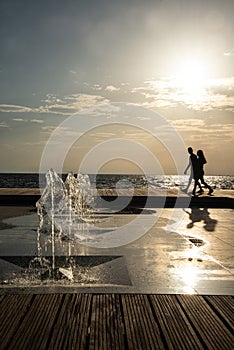 Thessaloniki, Greece. Waterfront promenade design, urban development project. Couple stolling at sunset