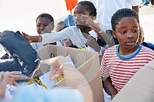 Theyre all excited to get their new school uniforms. volunteer workers handing out clothing to underprivileged children.