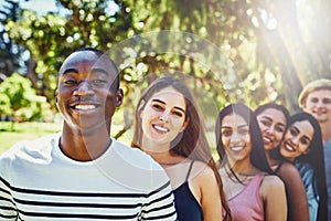 Theyre the best people ever and theyre my friends. Portrait of a group of friends standing in a row outdoors.