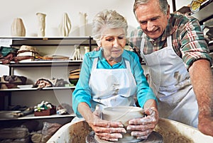 Theyre a couple of crafters. a senior couple making a ceramic pot together in a workshop.