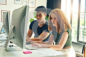 Theyre a dynamic design duo. two young creative businesspeople working on a computer in their office.