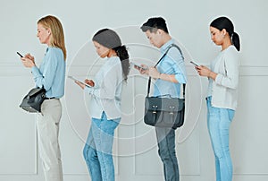 Theyre so easily bored these days. Shot of a group of businesspeople standing in a line at an office.