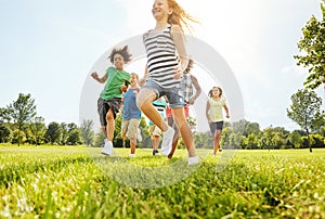 Theyre an energetic young bunch. a group of diverse and happy kids playing together outside.