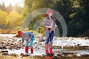 Theyre hooked on fishing. two young girls fishing by a river.