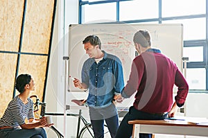 Theyre idea people. designers brainstorming on a whiteboard in an office.