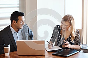 Theyre just a pair of overachievers. two young businesspeople working together in a modern office.