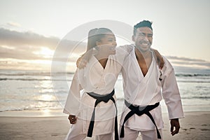 Theyre a kickass karate couple. Shot of two young martial artists practicing karate on the beach.