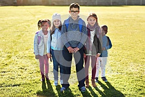 Theyre looking forward to a day full of learning. Portrait of a group of elementary school kids standing on the school