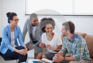 Theyre making great progress. a diverse group of designers having a meeting around a coffee table.