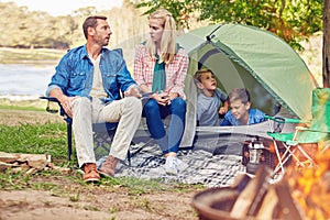 Theyre an outdoorsy family. a family of four camping in the woods.