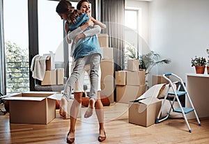 Theyre over the moon. Full length shot of an attractive young woman and her daughter dancing while moving into their new