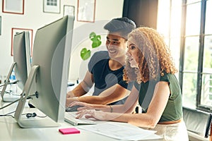 Theyre two of the best in the business. two young creative businesspeople working on a computer in their office.