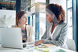 Theyve got some brilliant strategies to execute. two corporate businesswomen working together on a laptop in an office.