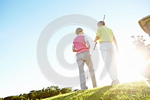 Theyve had a great game. Rear view shot of an elderly couple walking to their golf cart.