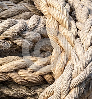 Thick braided rope is tied with a skein. Fishing rope background.