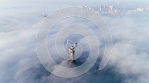 Thick clouds of autumn fog and the Motherland monument sticking out of them