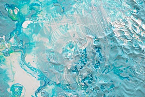 Thick dense layers of blue, white and turquoise paint