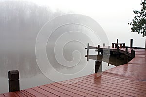 Thick Fog Covers Wooden Dock And Lake On Winter Day