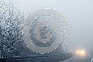 Thick fog on the highway in Europe on a winter day. The danger of driving of vehicles on roads in bad foggy weather. Insurance of