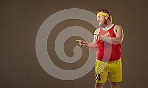 Thick funny man in sports clothes points with his finger.
