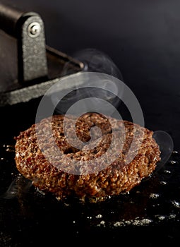 Thick juicy beef patty sizzling on the grill