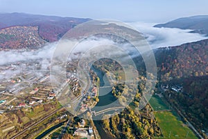 Thick morning fog over the village and the river in the mountains.