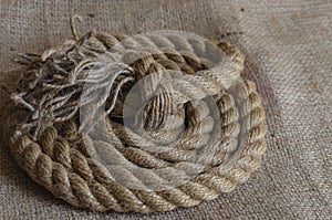 Thick natural rope wound in a reel on sackcloth
