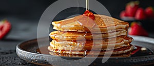 Thick pancakes with golden syrup pouring and bubbling from above. Horizontal banner 7:3