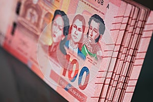 A thick pile of money from Bolivia, Banknotes with a face value of one hundred Bolivianos. Reflection in the glass photo