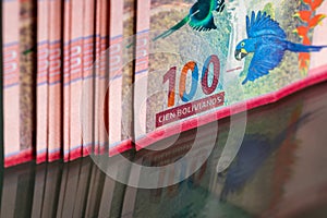 A thick pile of money from Bolivia, Banknotes with a face value of one hundred Bolivianos. Reflection in the glass photo