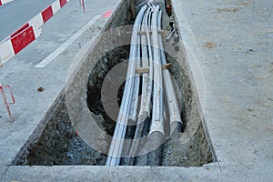 Thick polypropylene pipes in a building pit on a street of civil engineering building site  with barrier planks in red and white