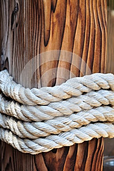 Thick rope around a wooden mooring bollard, Croatia