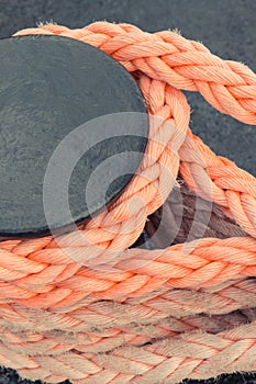 Thick rope and black mooring bollard. Detail of port. Yachting