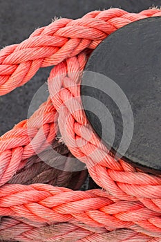 Thick rope and black mooring bollard. Detail of port. Yachting