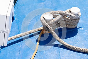 Thick rope on the ship is coiling on two bitts