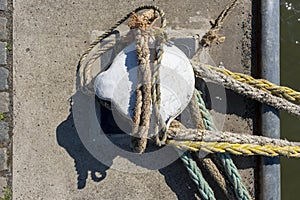 Thick ropes wrapped around a mooring post in the port of rotterdam