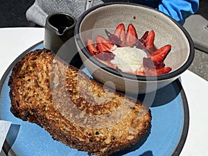 Thick slice of rustic whole grain whole wheat French toast with fresh strawberries and mascarpone