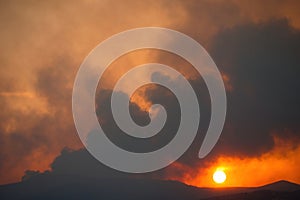 thick smoke from a fire at sunset, large fire near the city of Volos, Greece