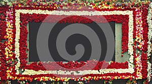 Thick square frame decorated with red and white roses around on a dark background