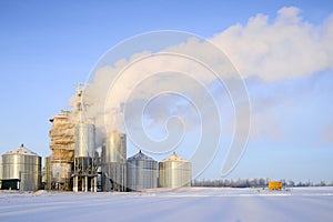 Thick steam from the pipes of a grain drying plant photo